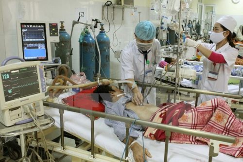 Nhân viên y tế chăm sóc bệnh nhân nằm viện. (Ảnh: TTXVN/Vietnm+)